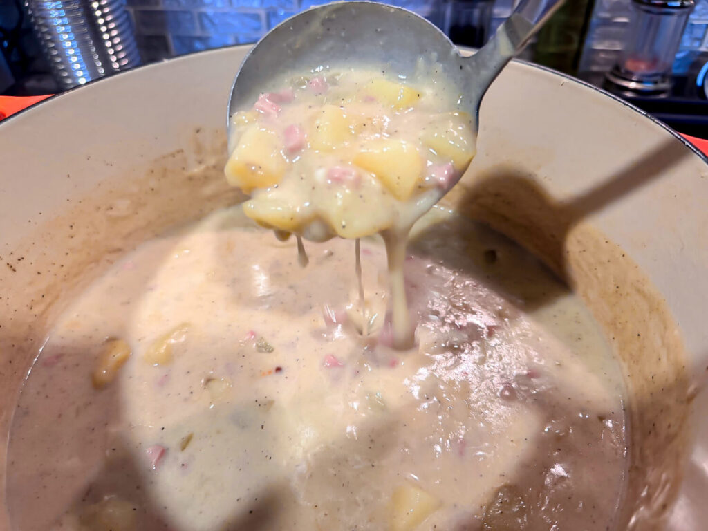 photo of spoon full of ham and potato soup