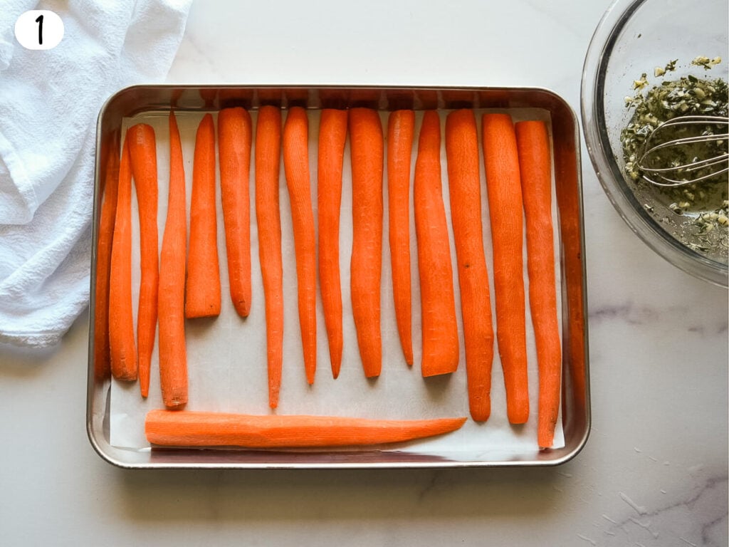 photo of carrots cut in half face down on a cooking tray