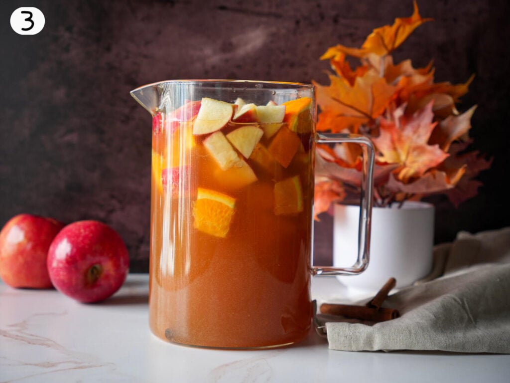 step 3 of apple cider sangria resting in a pitcher
