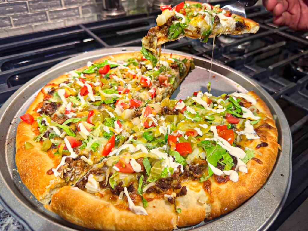 action shot of pulling a slice of taco pizza