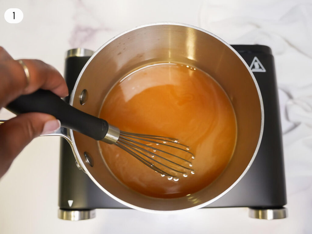 photo of reduced apple cider in a saucepan with a whisk