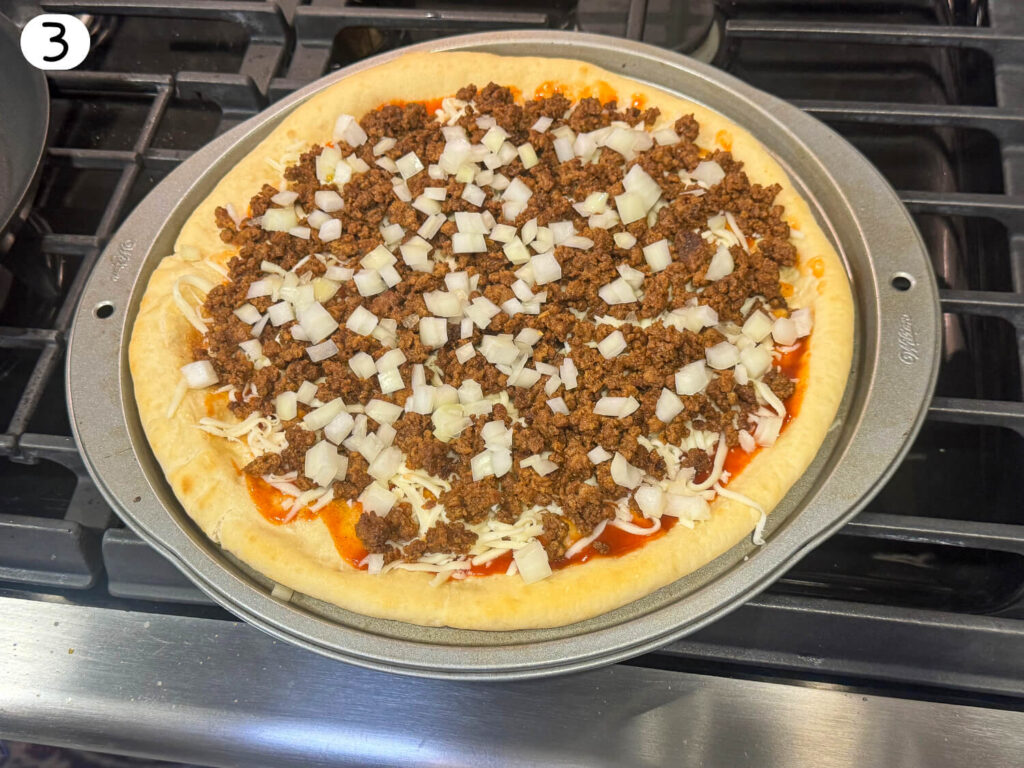 photo of taco pizza with ground beef and onions on top