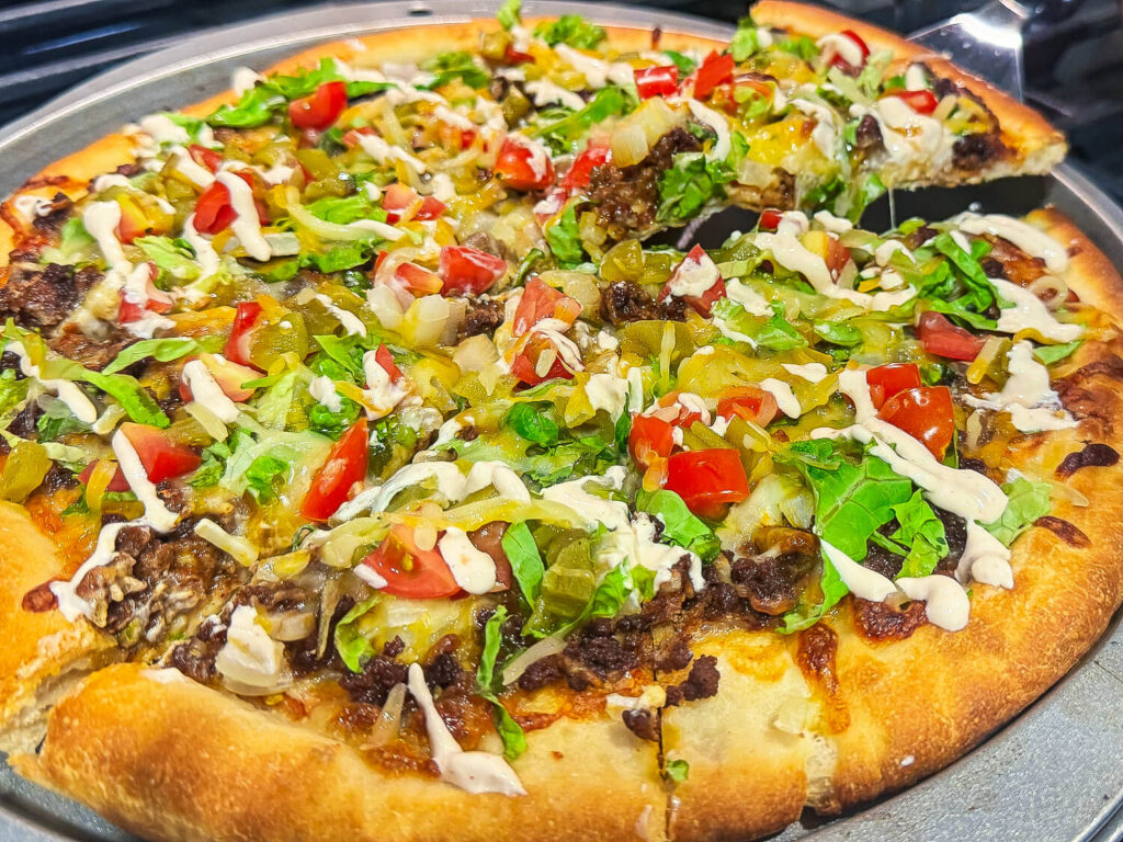 close up photo of taco pizza being sliced