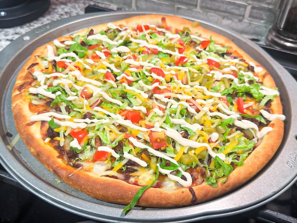 close up photo of taco pizza with sour cream