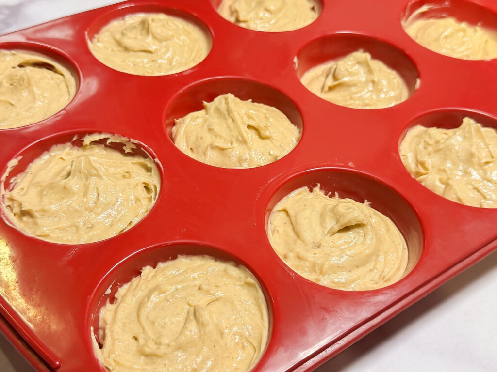 Apple Cider Muffin batter in a red muffin pan