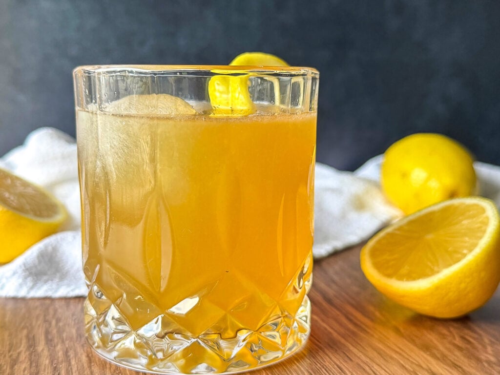 Finished Gold Rush Cocktail recipe with a lemon twist