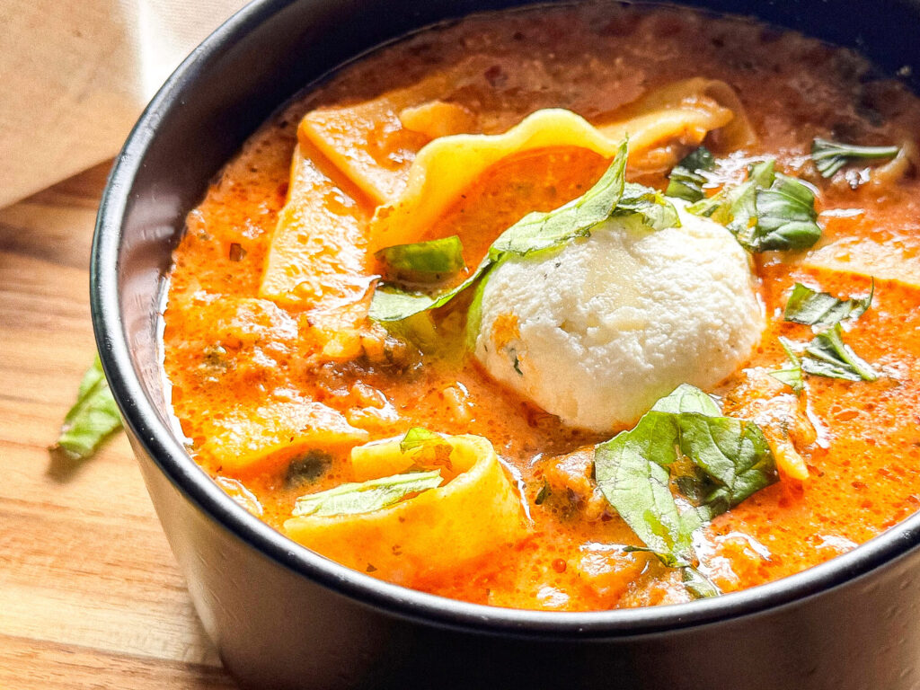 side photo of lasagna soup in a black bowl