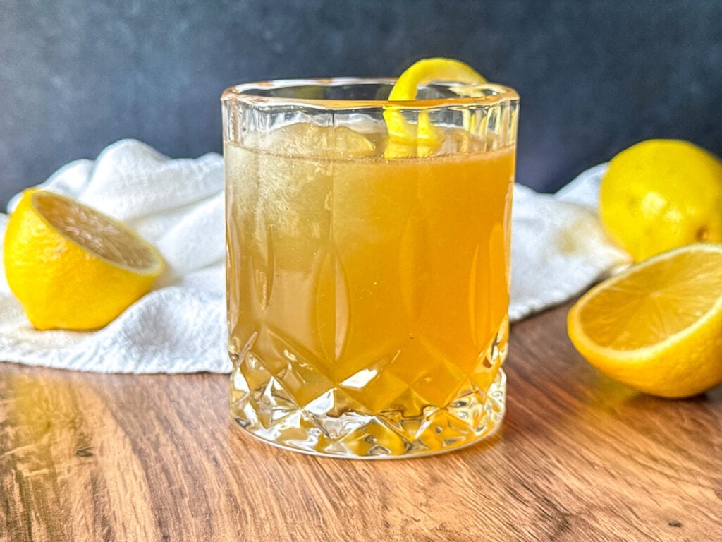 Finished Gold Rush Cocktail recipe with a lemon twist