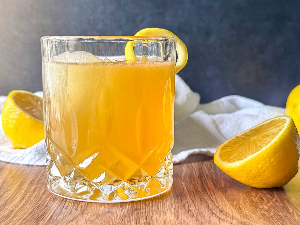 Finished Gold Rush Cocktail recipe with a lemon twist