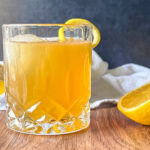 Finished Gold Rush Cocktail recipe with a lemon twist
