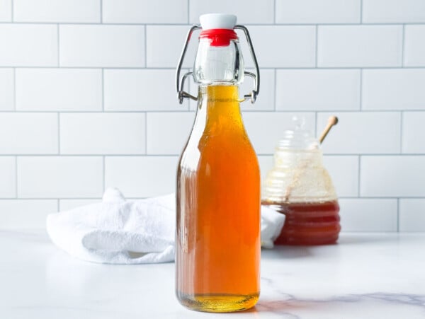 photo of honey syrup next to a jar of honey