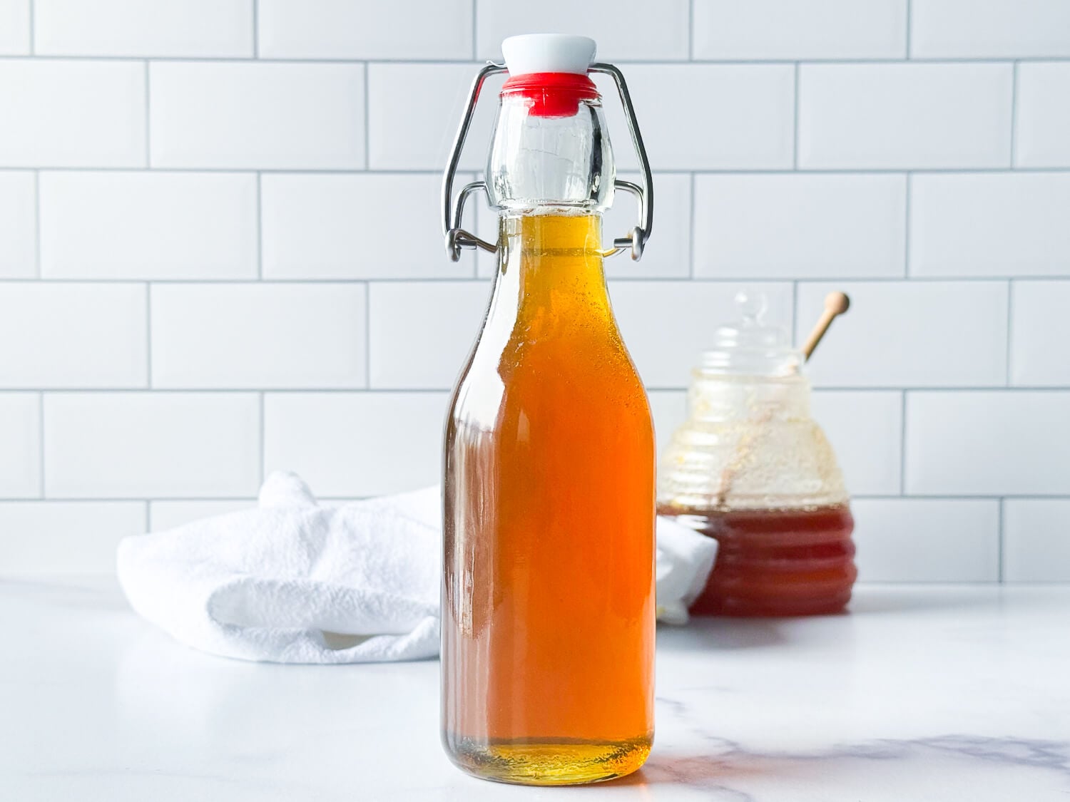 photo of honey syrup next to a jar of honey