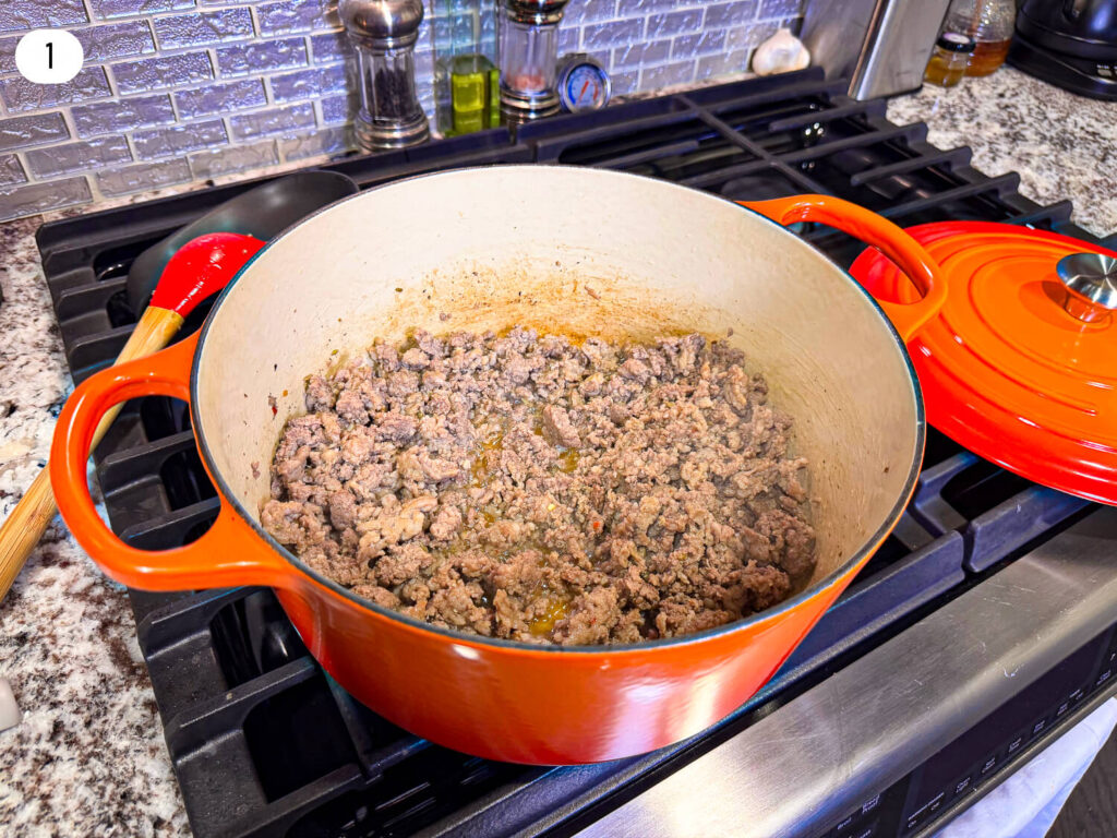 photo of ground beef and pork for lasagna soup in a dutch oven