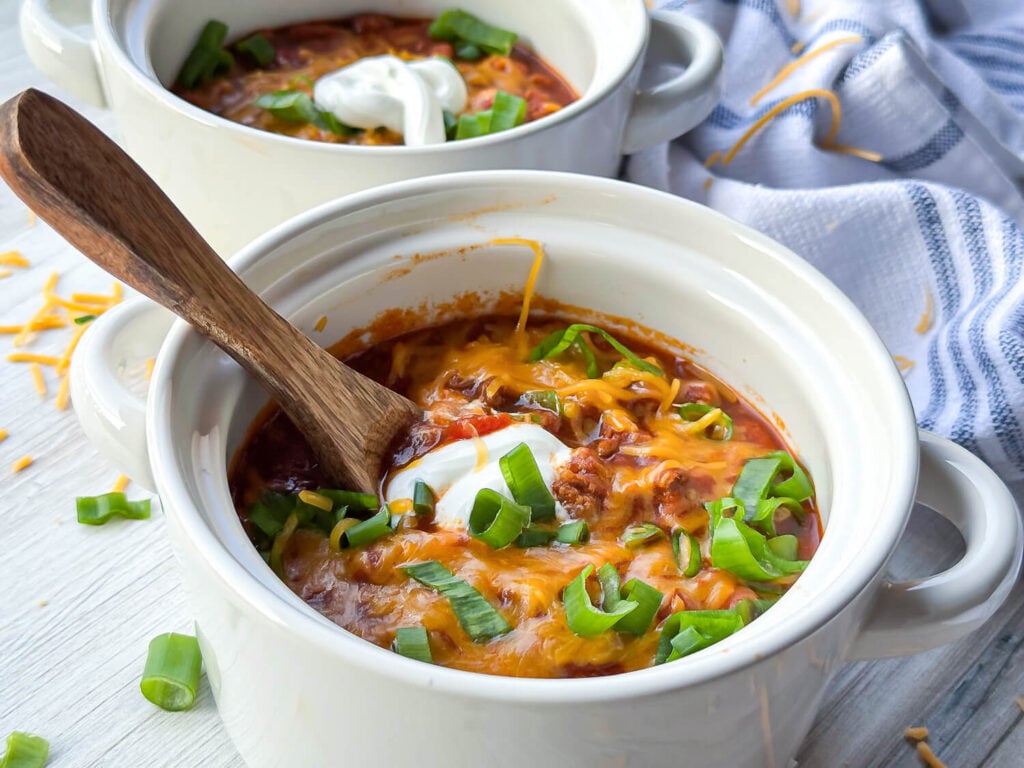 photo of Classic Homemade Chili with sour cream , cheese, and green onions on top
