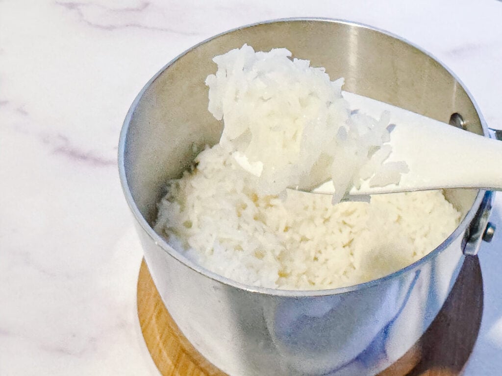 photo of cooked white rice being scooped out of the pot