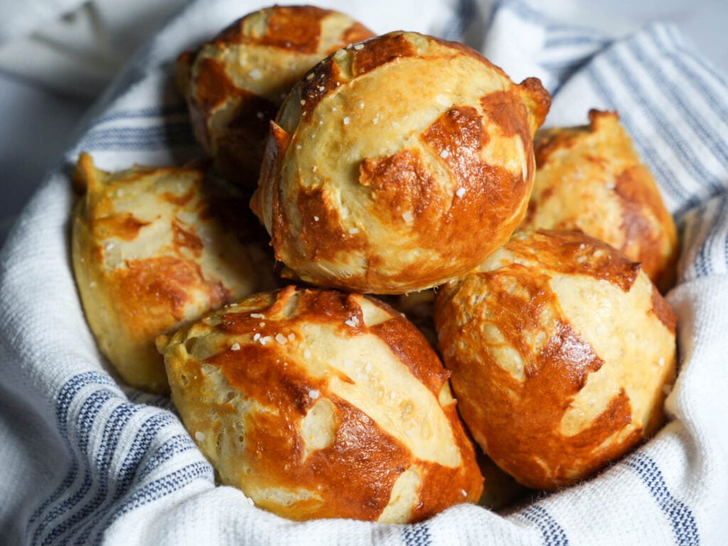 Close up photo of pretzel buns with salt in a basket