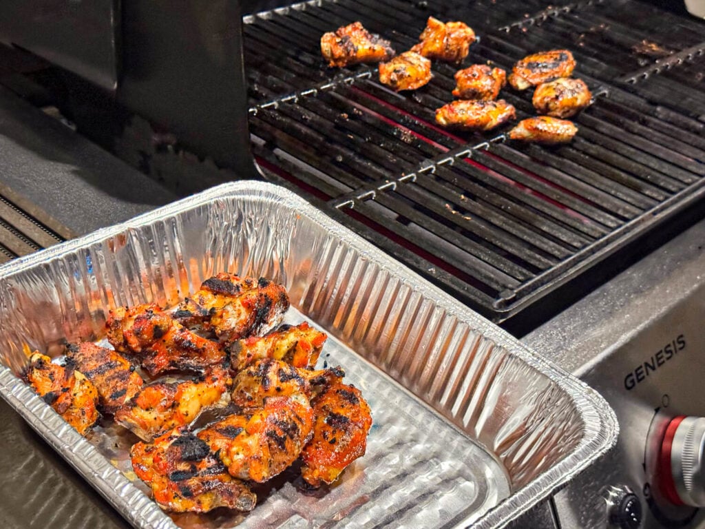 Grilled Chicken Wings in a pan being removed from the grill