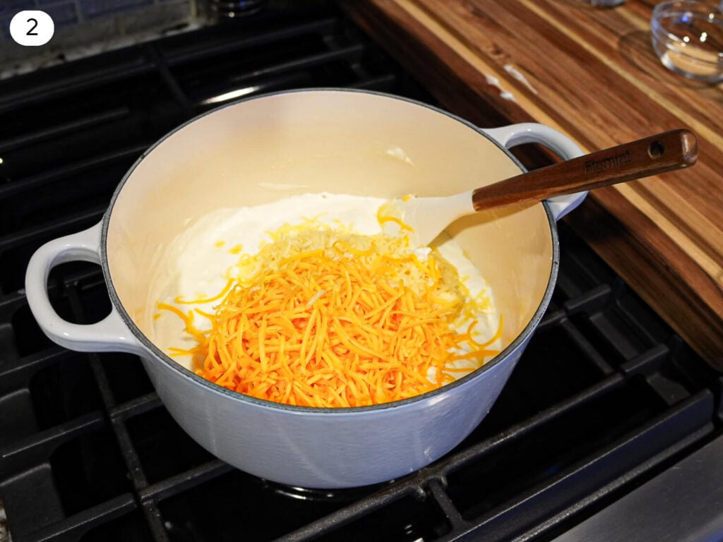 Step 2 - Photo of adding shredded cheese to melt into pot