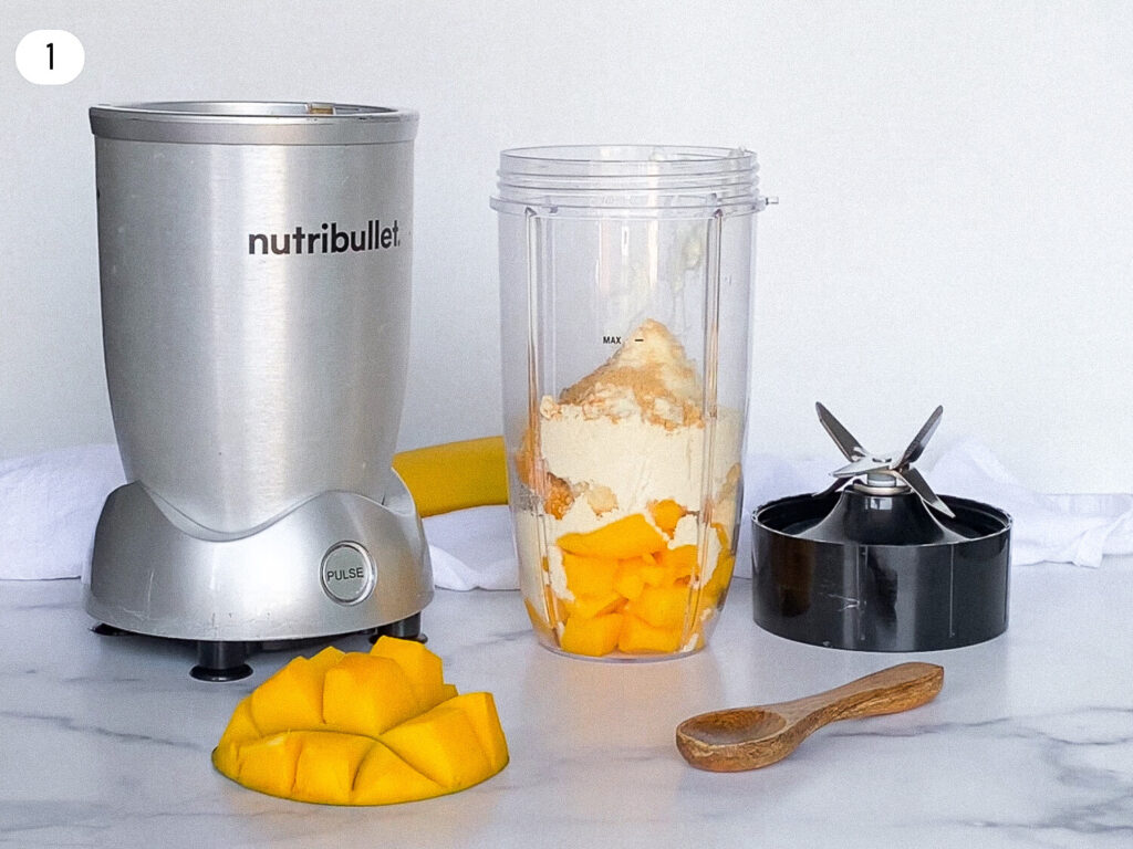photo of a nutribulet blender next to a cup full of ingredients for the smoothie