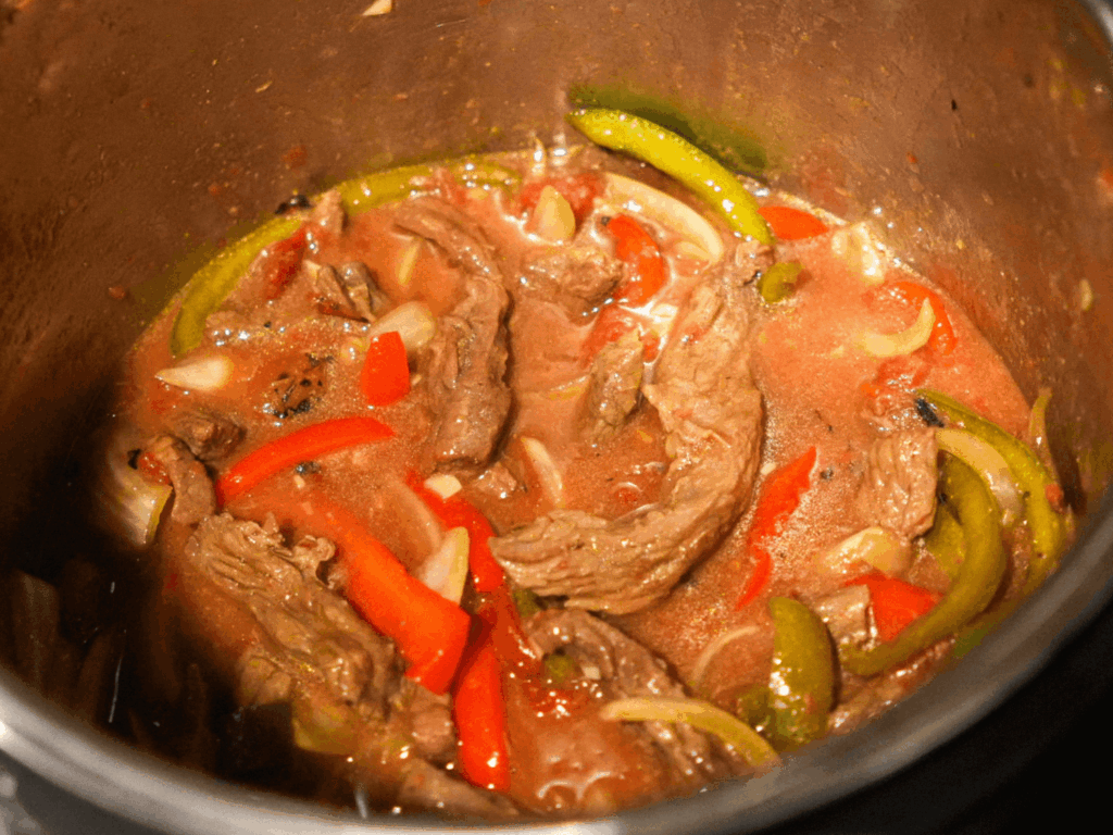 close up photo of pepper steak cooking in the slow cooker