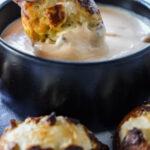 close up photo of pretzel being dipped in beer cheese dip