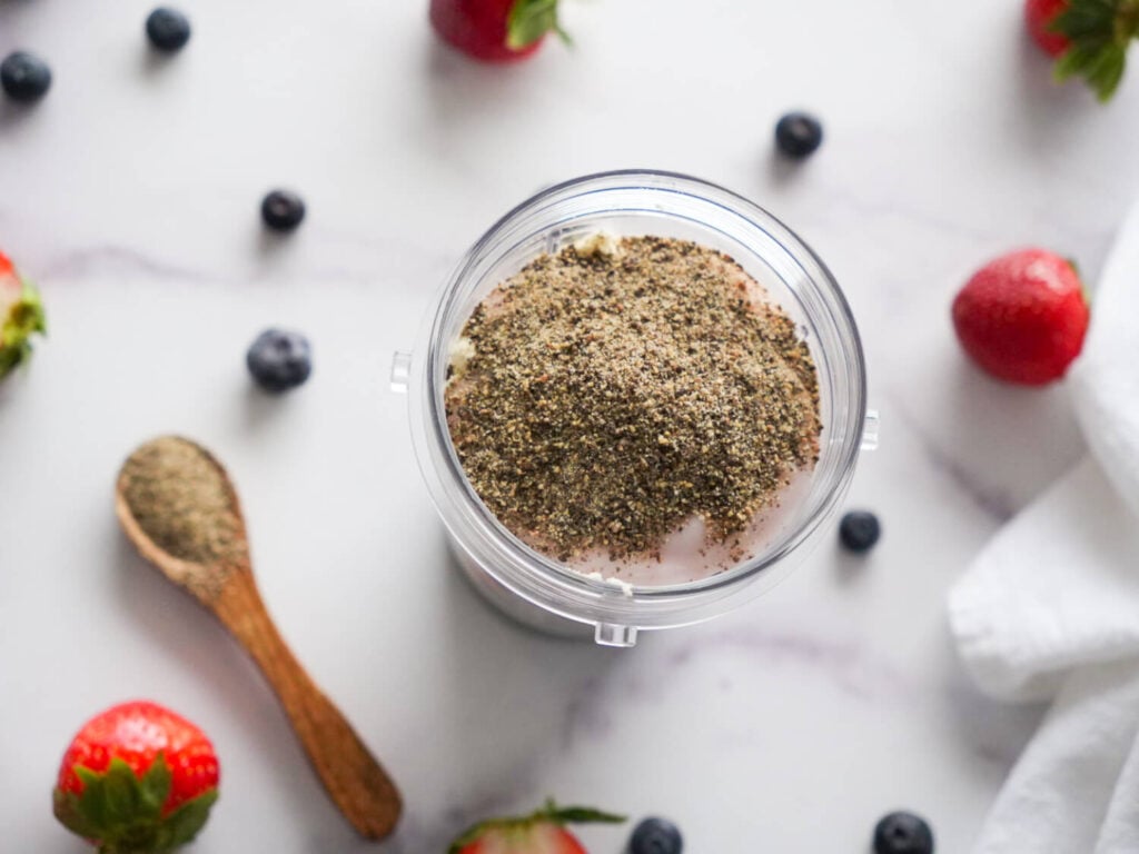 overhead photo of ingredients in a blender container next to a spoonful of chia seeds