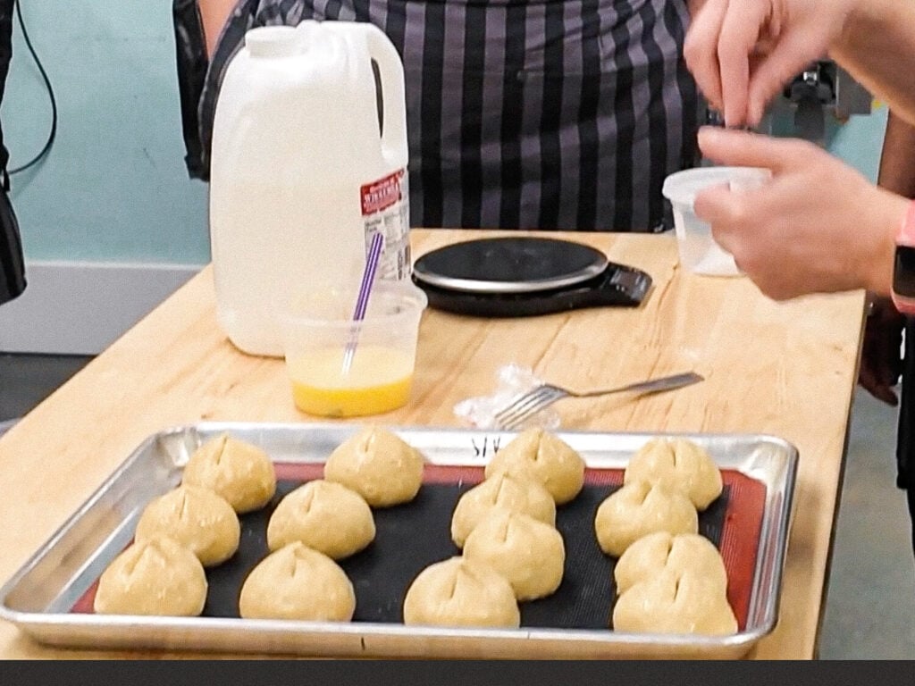 photo of chef adding salt to pretzel buns