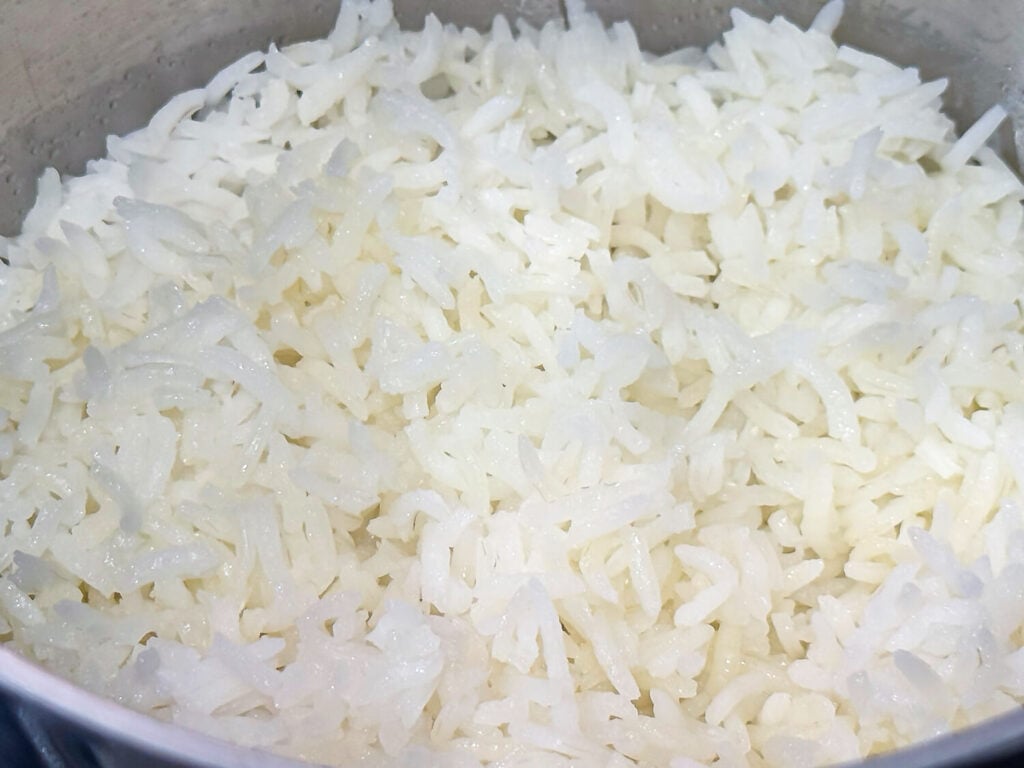 close up photo of cooked white rice in a silver pot