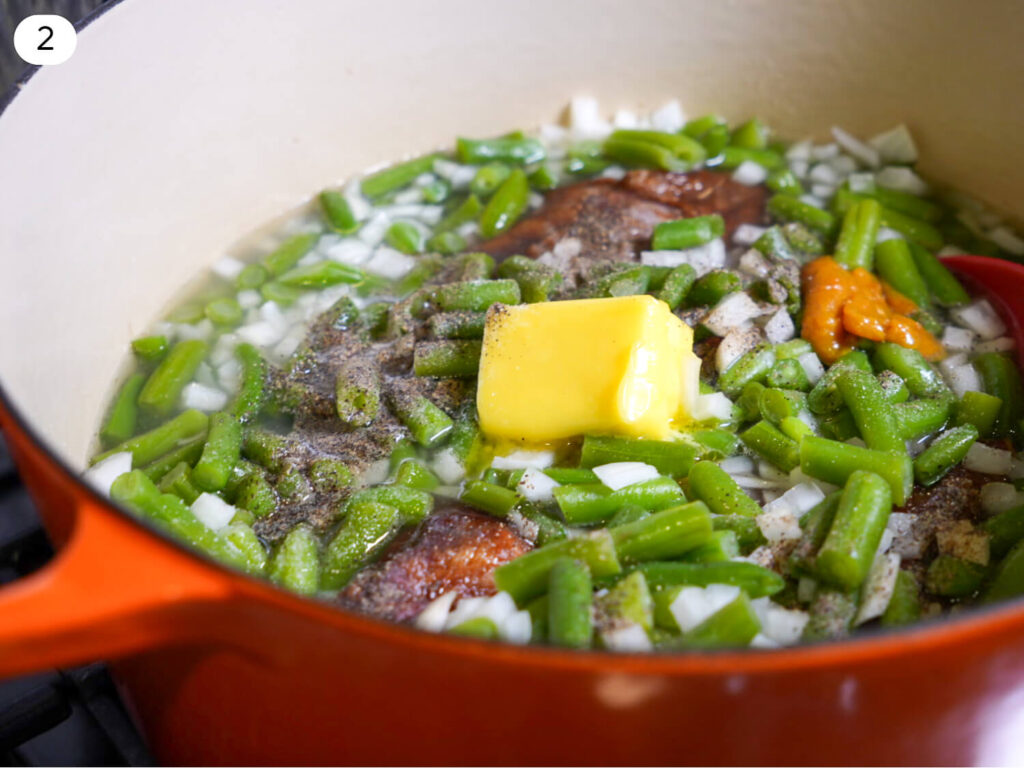 photo of green beans in a pot with aromatics and butter