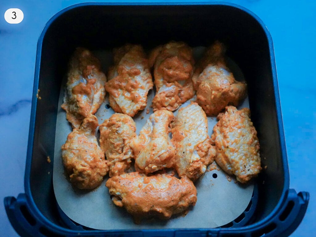 step 3 seasoned wings in an air fryer basket