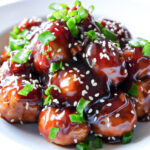HERO photo of Honey Garlic Meatballs garnished with sesame seeds and green onions