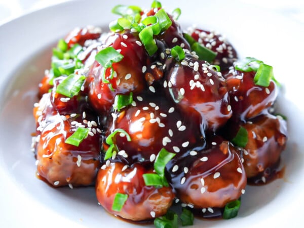 HERO photo of Honey Garlic Meatballs garnished with sesame seeds and green onions