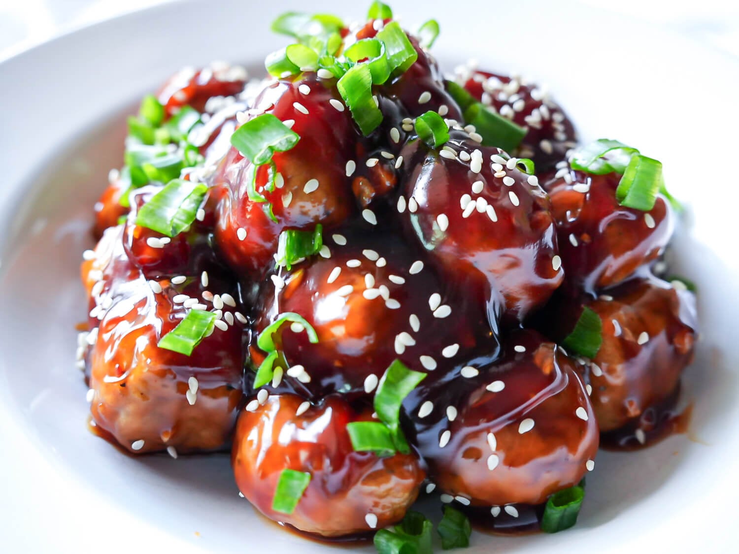HERO photo of Honey Garlic Meatballs garnished with sesame seeds and green onions