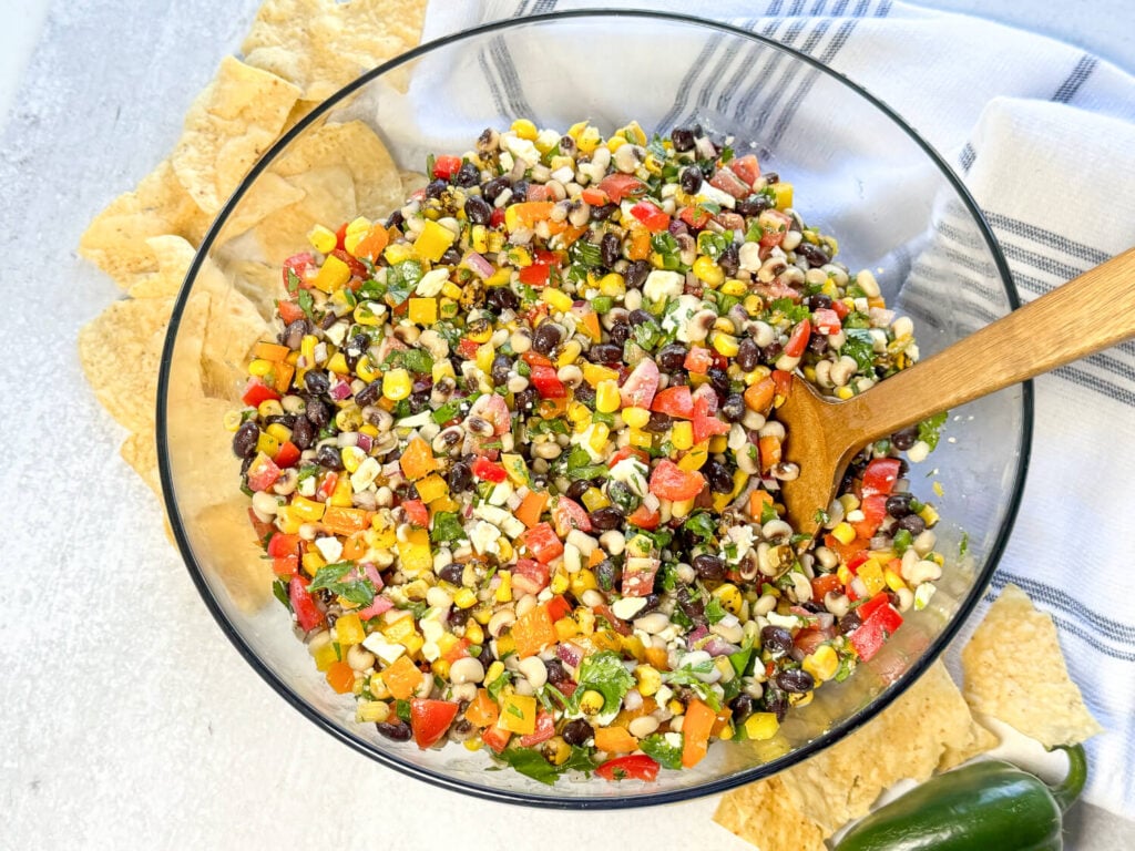 Overhead photo of Black Eyed Pea Salad in a glass bowl next to tortilla chips