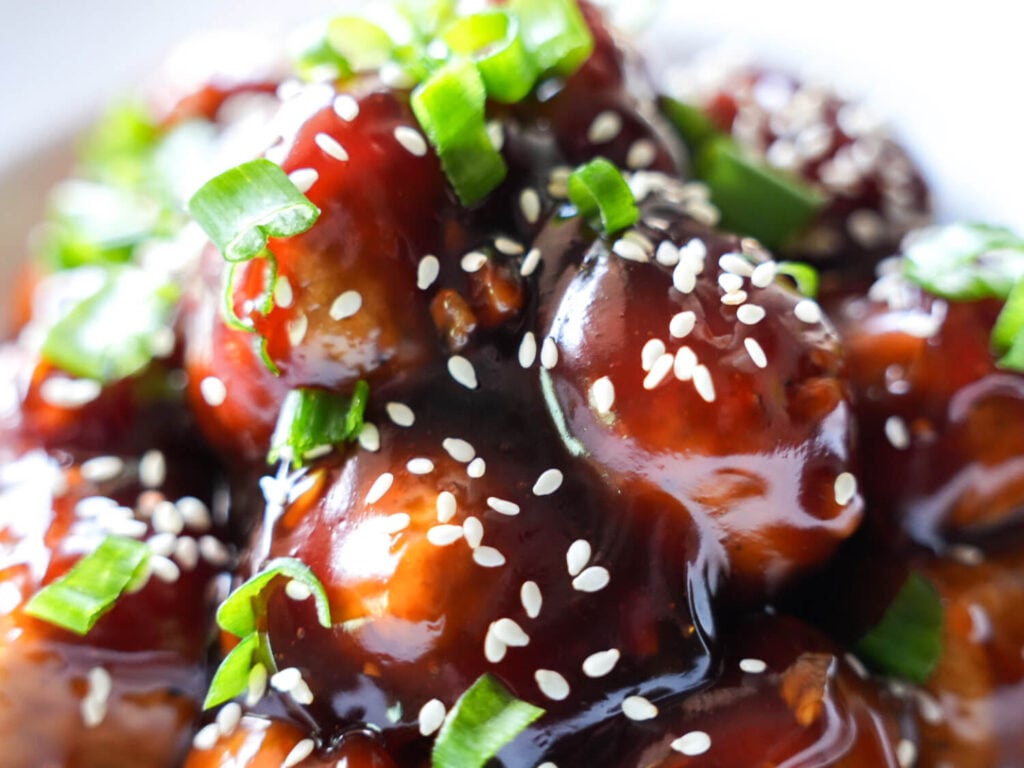 close up photo of Honey Garlic Meatballs with green onions and sesame seeds