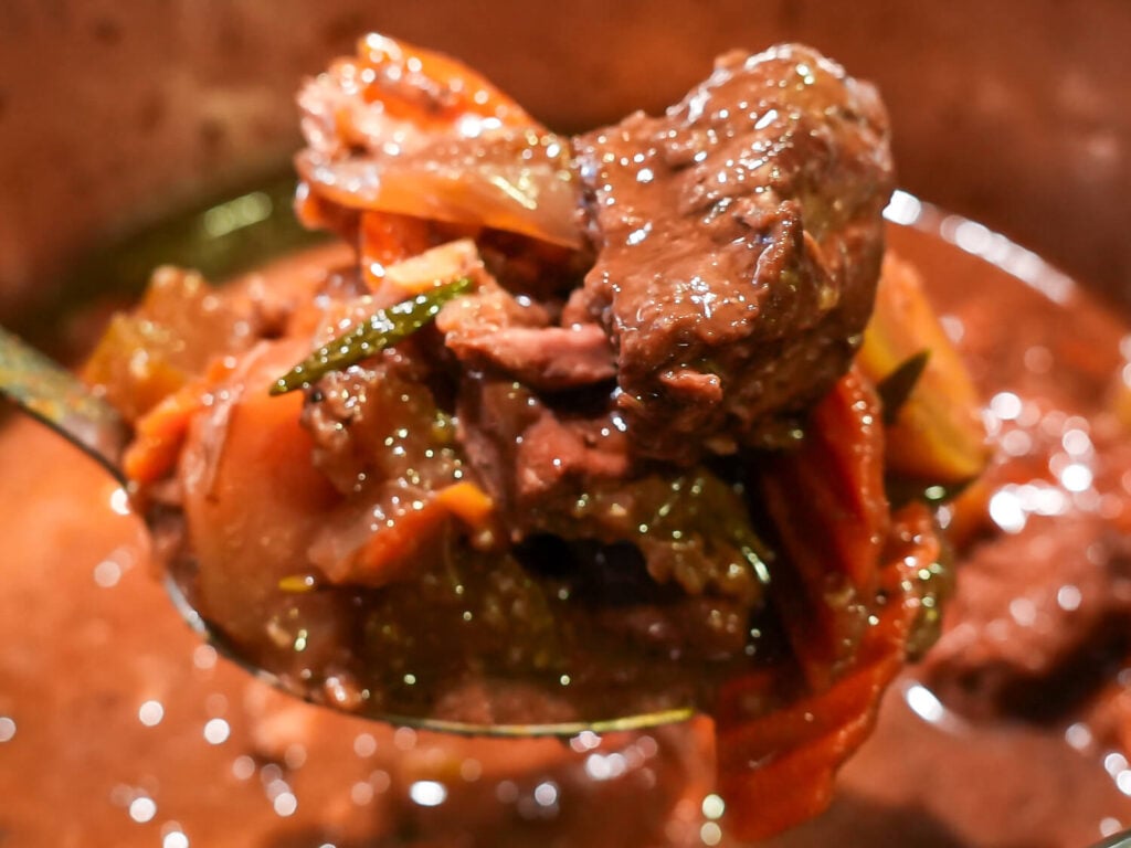 close up photo of Slow Cooker Beef Stew in the crockpot being picked up with a spoon