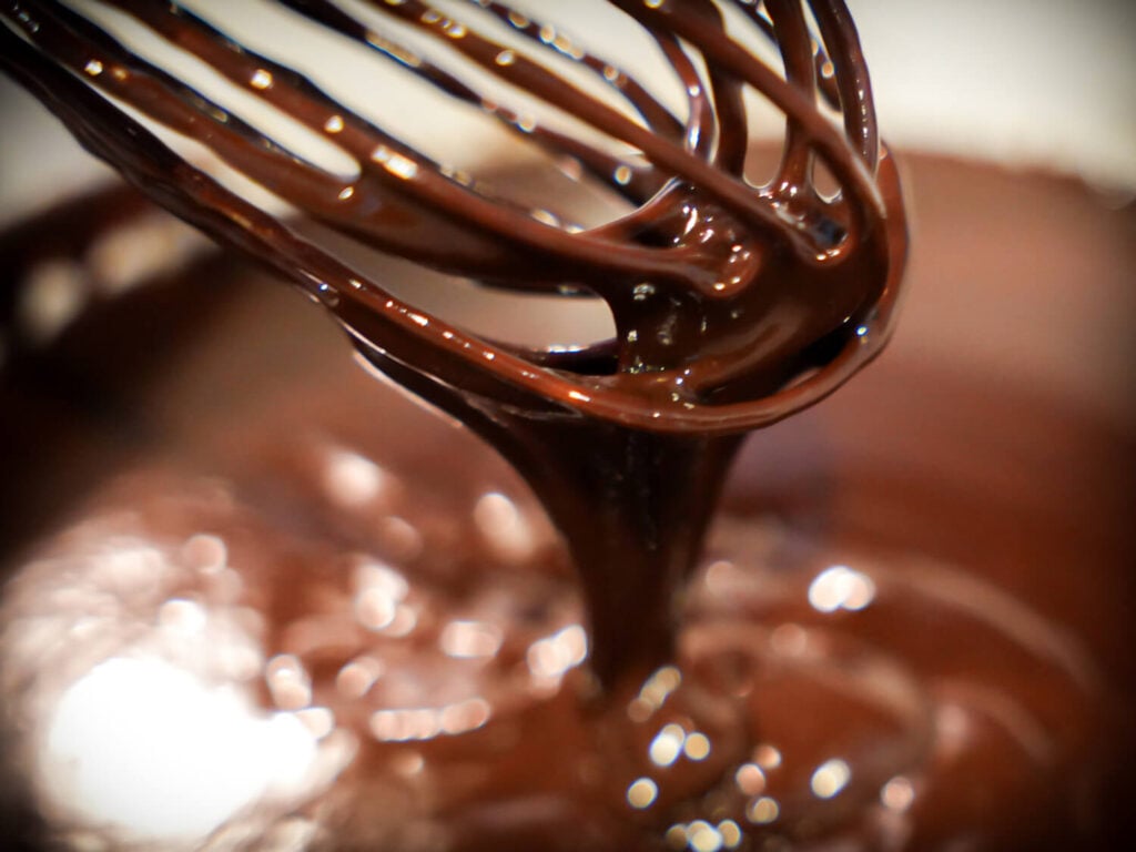close up photo of chocolate fondue on a whisk