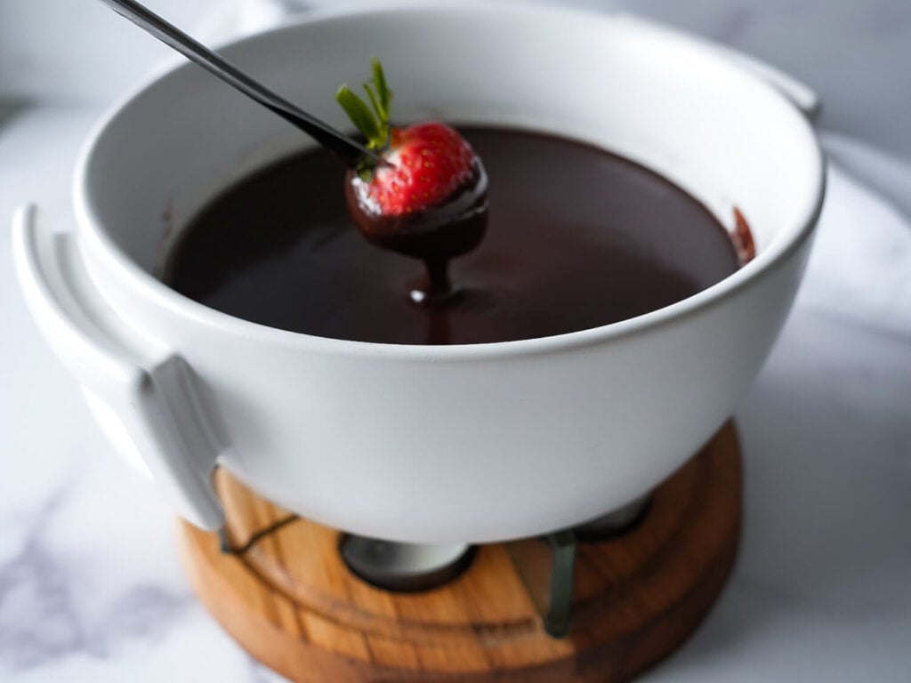 photo of a strawberry being dipped in chocolate fondue