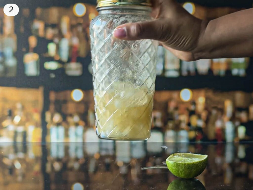 step 2 photo of shaking ingredients in a cocktail shaker
