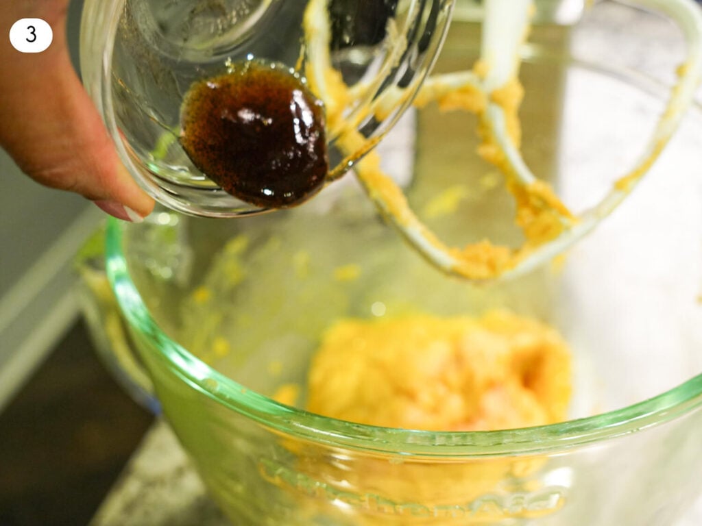 step 3 photo showing vanilla bean paste being poured into butter sugar mixture