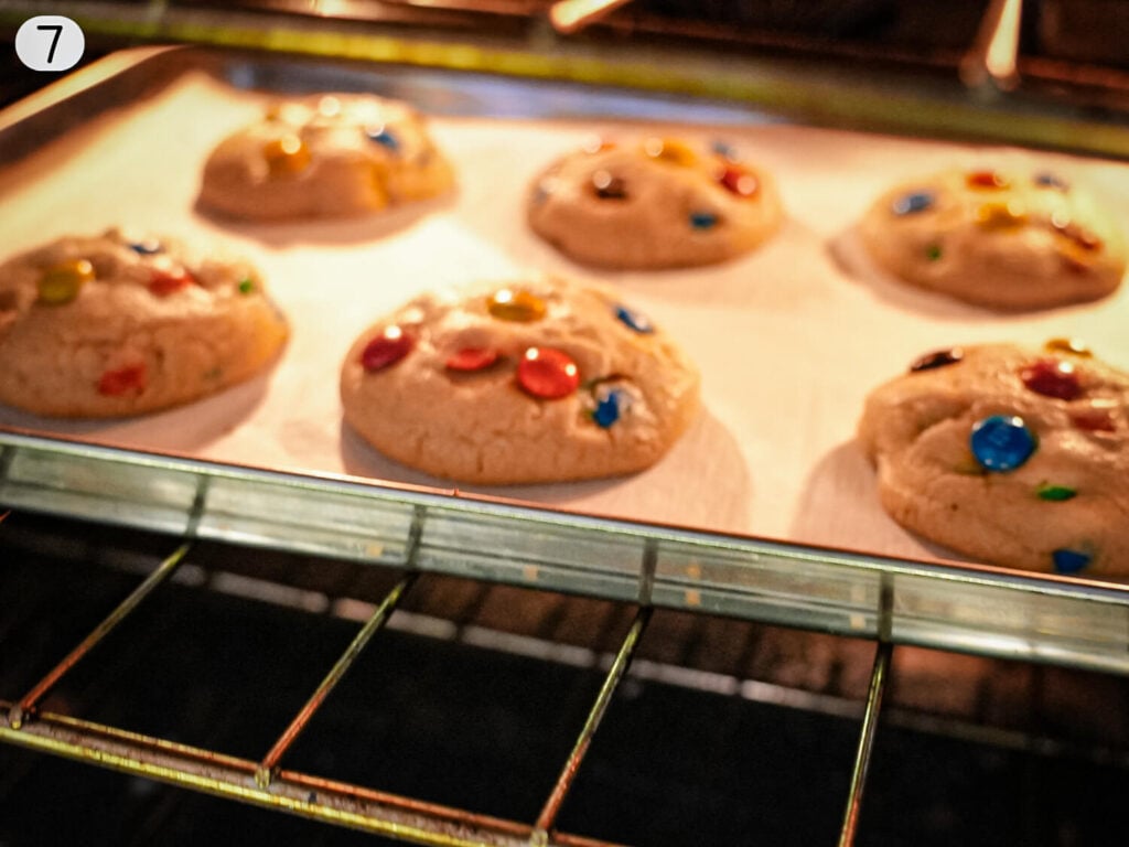 step 7 photo showing M&M cookies baking in the oven