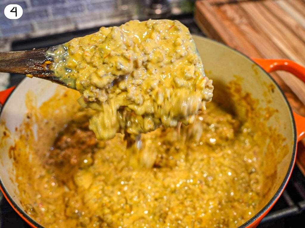 step four photo of cooked Sausage Cheese Dip on a wooden spoon