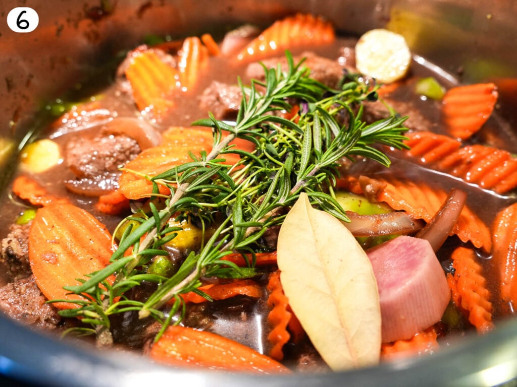 step six photo of adding herbs on top . Cook for hours 2