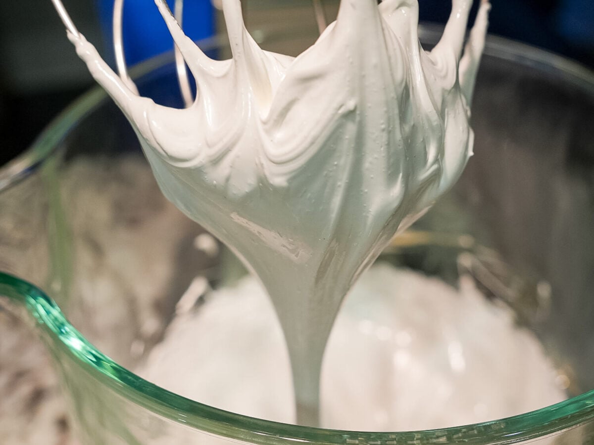 Close up photo of Swiss Meringue dripping off of a whisk