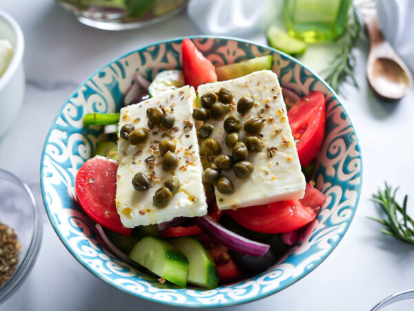 HERO photo of greek salad in a blue and white bowl