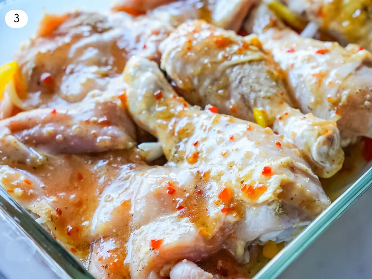 Photo of chicken legs and thighs in a glass dish with Italian dressing on top