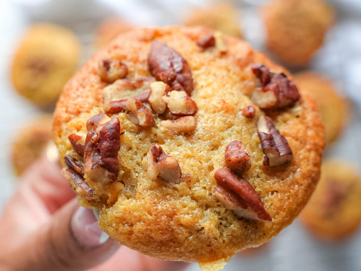 close up photo of one banana nut muffin with walnuts on top