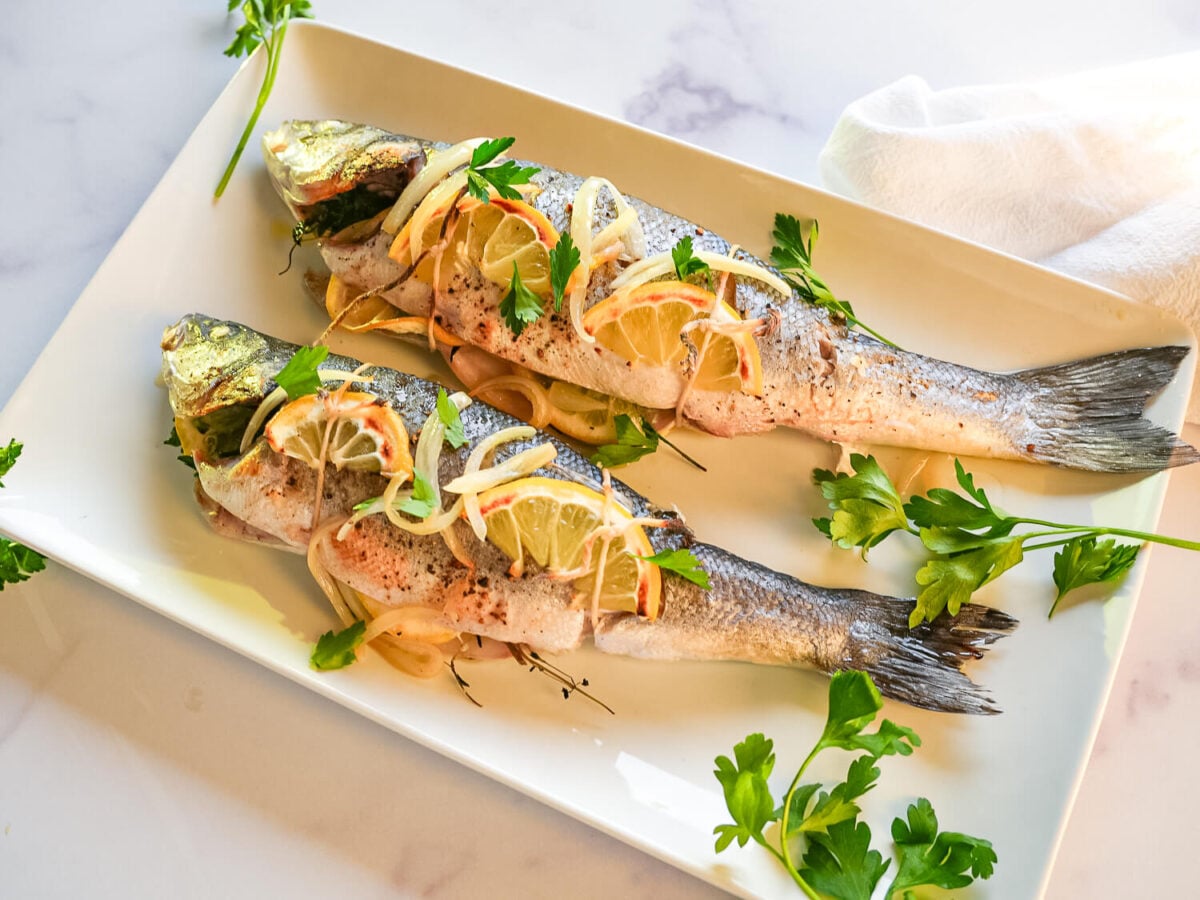 overhead photo of Roasted Branzino on a white plate on a marble surface-2