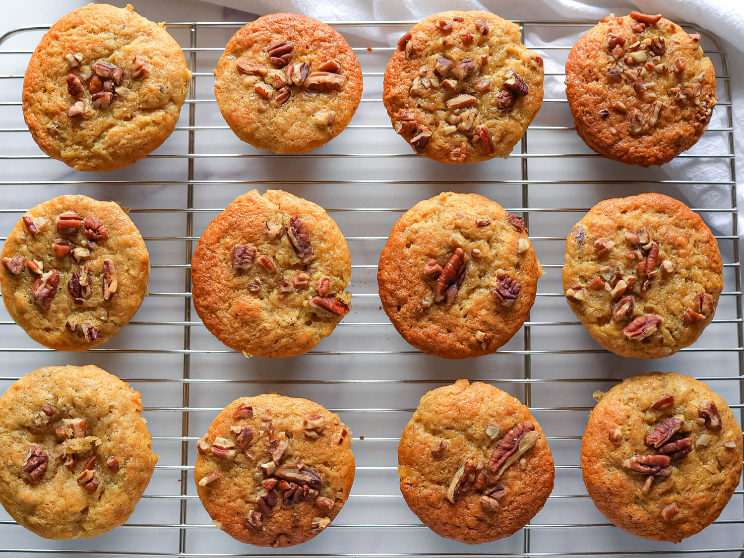 photo of a dozen baked banana nut muffins on a wire rack