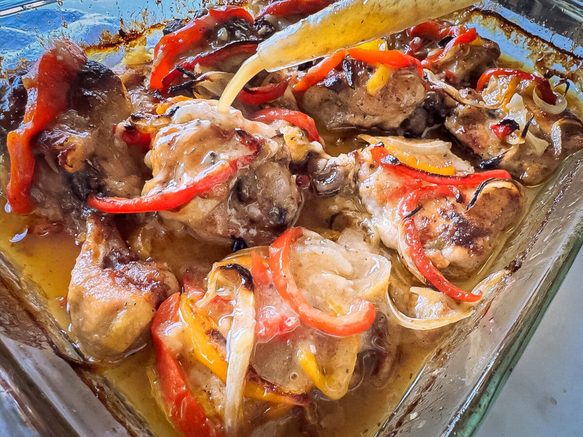 photo of baked Italian Dressing Chicken and pouring gravy drippings on top
